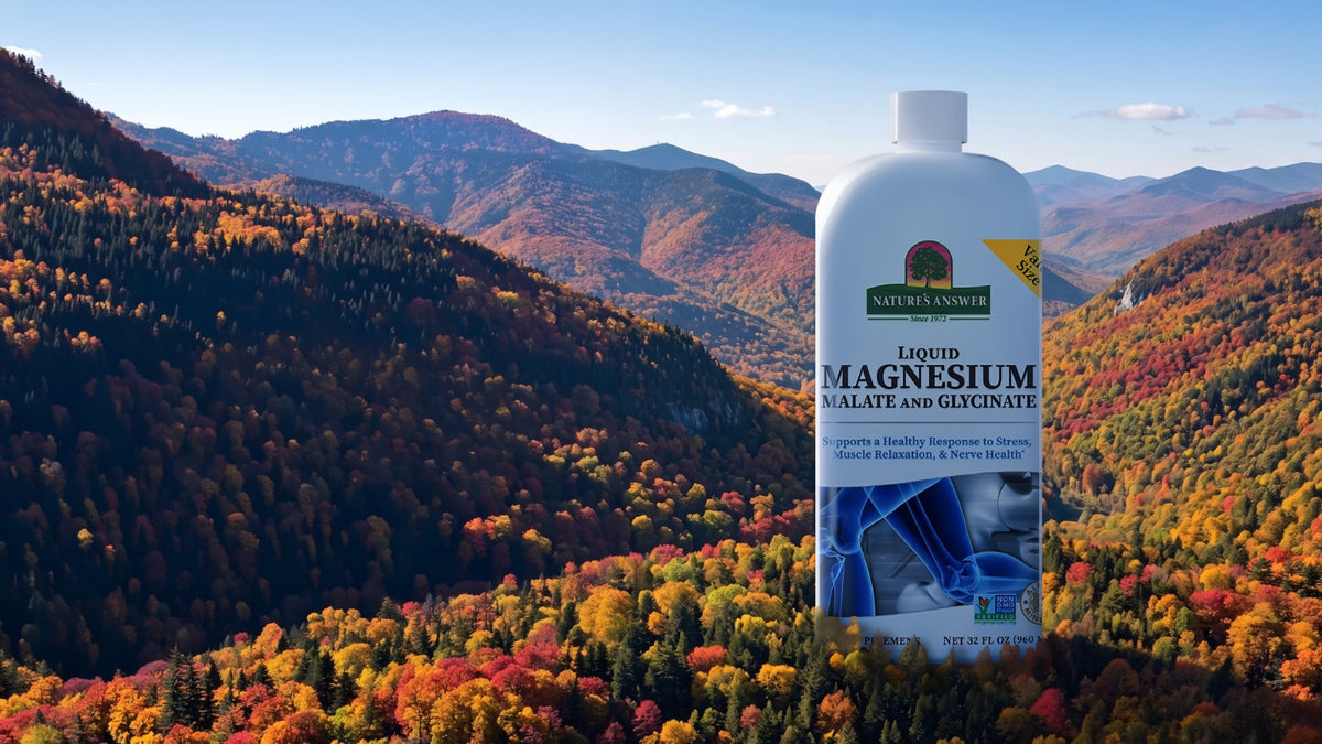 A bottle of Nature's Answer Liquid Magnesium supplement standing in front of a colorful autumn mountain landscape.